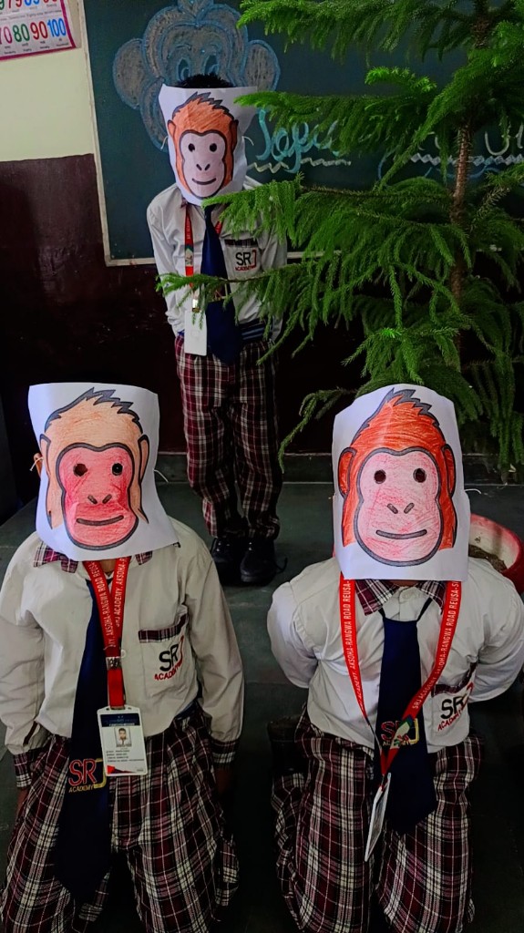 Three SRJ Academy students wearing handmade monkey masks